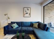 Thumbnail 1 of 7 - a living room with a blue couch and a coffee table