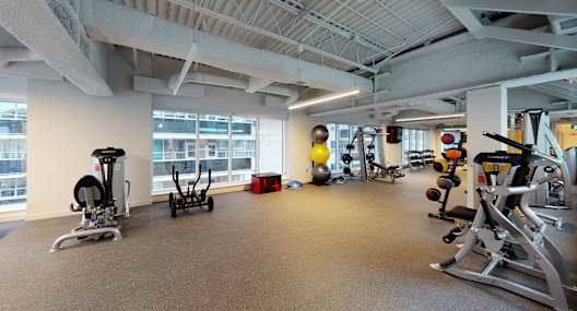 A gym with a variety of equipment including weights and machines.