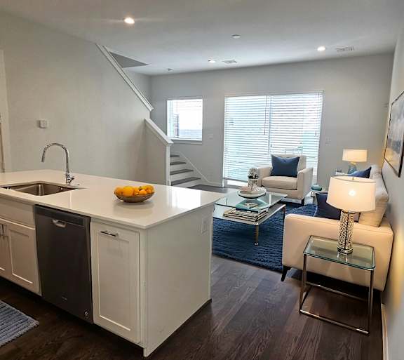 A modern kitchen with white cabinets and a glass table.