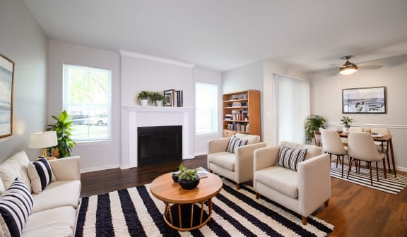 a living room with white furniture and a fireplace