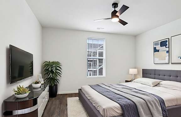 Image of a bedroom with a tv, bed and a window