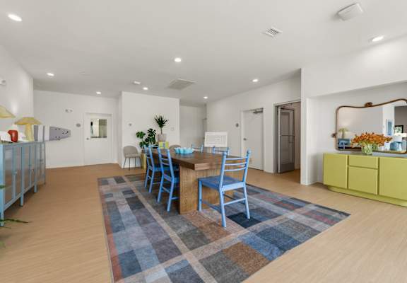 A dining room with a blue rug and chairs.at The Teale New Haven Apartments, Melbourne, FL, 32904