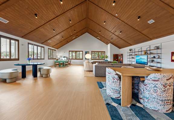 A room with a wooden floor and ceiling, furnished with a table and chairs. at The Teale New Haven Apartments, Melbourne, FL, 32904