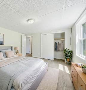 A room with a window and a wood floor.