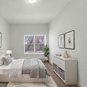 A bedroom with a bed, nightstands, and pictures on the wall.