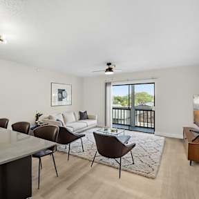A modern dining room with a glass table and chairs.