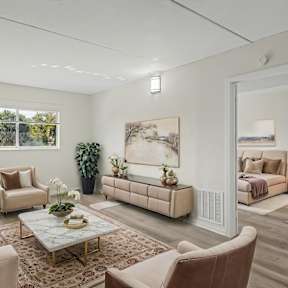 A living room with a large painting on the wall and a couch with a pillow on it.