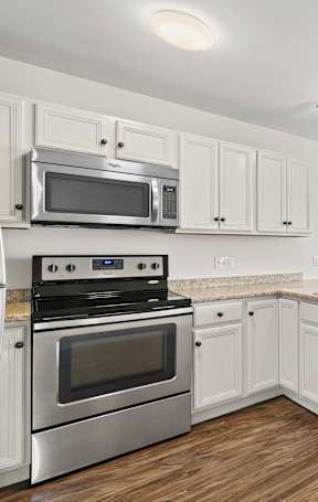 A kitchen with white cabinets and stainless steel appliances.