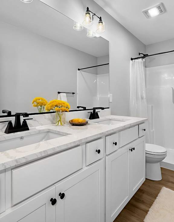 A bathroom with a white sink and a white toilet.