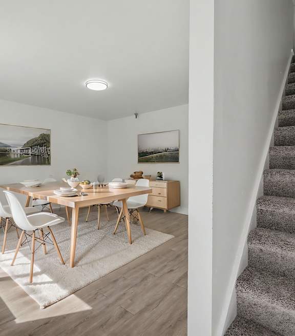 A dining room with a wooden table and chairs.