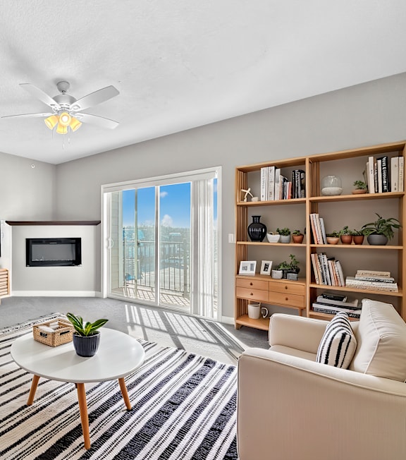 A living room with a white couch, a coffee table, and a television.