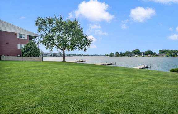 Lakefront lawn with private docks and water views at Cass Lake Shore Club Apartments, Waterford Twp, MI