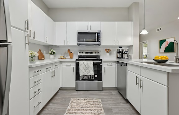 a kitchen with white cabinets and stainless steel appliances