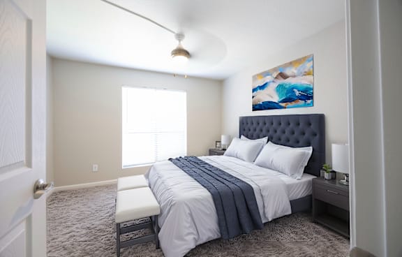 a bedroom with a white bed and a blue and white comforter