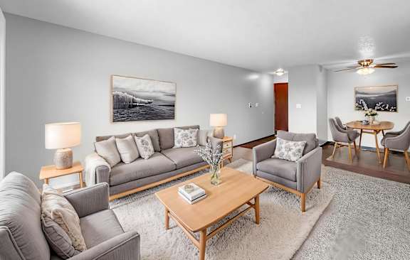 A living room with a grey couch, a coffee table, and a painting on the wall.