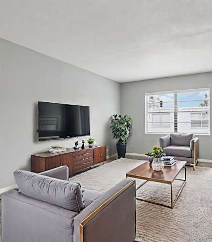 A living room with grey couches and a television.