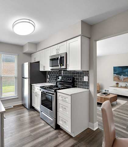 A modern kitchen with a refrigerator, oven, and sink.