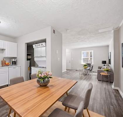 A modern kitchen with a wooden table and chairs.