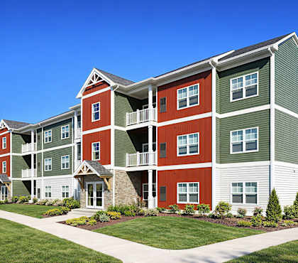 A large apartment building with red and green exterior walls.