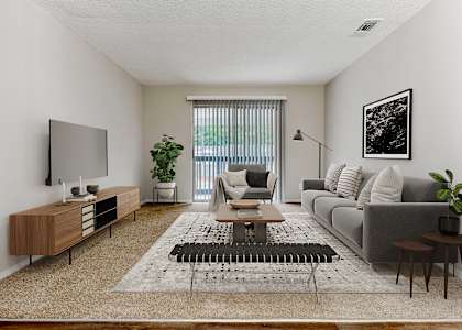 a spacious living room with white walls and carpeting
