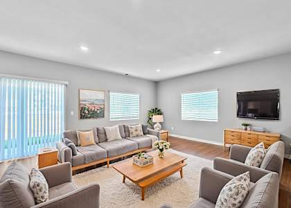 A living room with a grey couch, a coffee table, and a television.