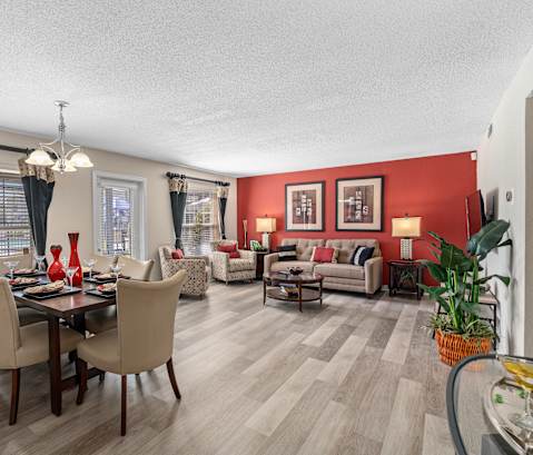 a living room and dining room with red walls and wooden floors at Oak Reserve at Winter Park, Winter Park