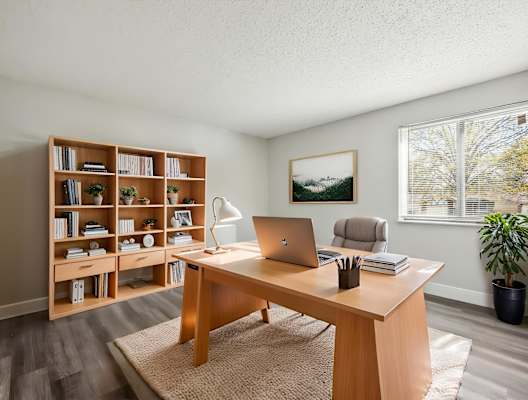 A room with a desk, chair, and bookshelf.
