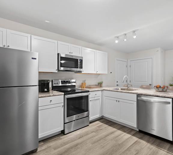 a kitchen with stainless steel appliances and white cabinets