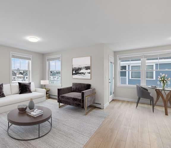A living room with a white couch, a grey armchair, and a coffee table.