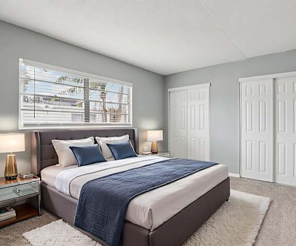 A bedroom with a large bed and a flat screen TV mounted on the wall.