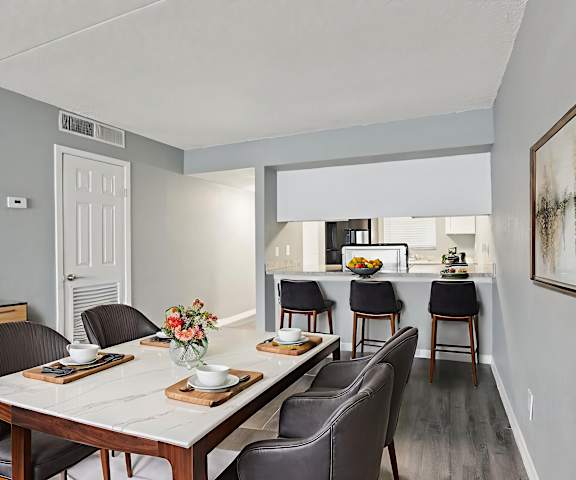 A dining room with a table set for six.