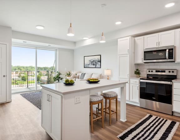 an open kitchen with a large island with two stools