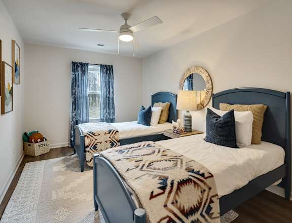 A bedroom with two beds and a ceiling fan.