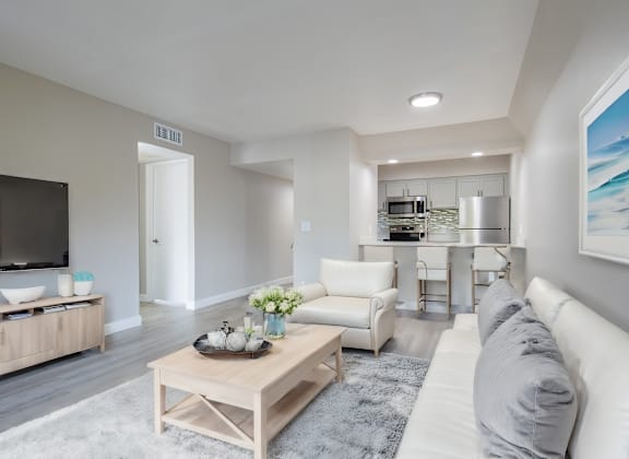 A modern living room with a white sofa and a wooden coffee table. at Sofia Apartments, Tempe, AZ, 85283