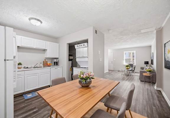 A modern kitchen with a wooden table and chairs.