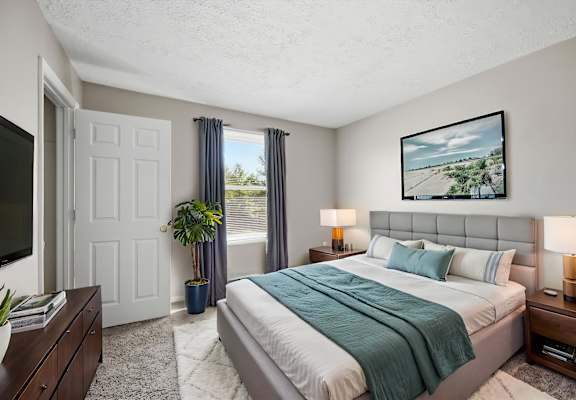 A bedroom with a large bed and a painting on the wall.