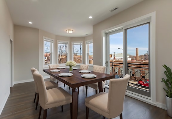 a dining room with a wooden table and chairs and a large window