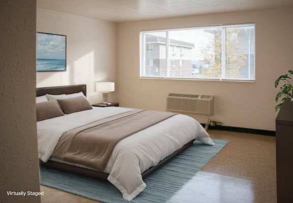 A bedroom with a bed, nightstand, and window.