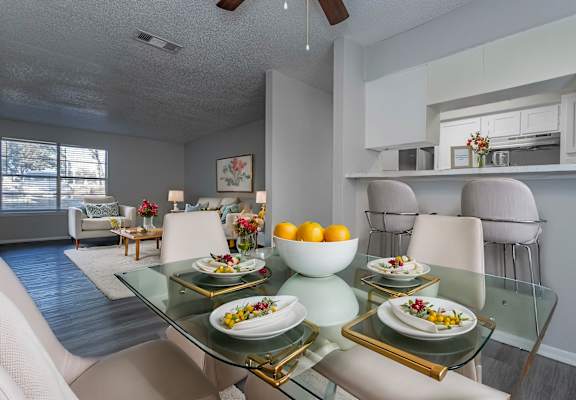 A dining room with a glass table and chairs.