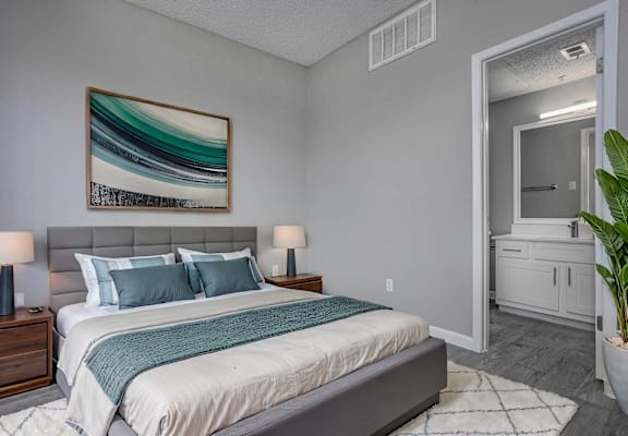 a bedroom with grey walls and a white bed