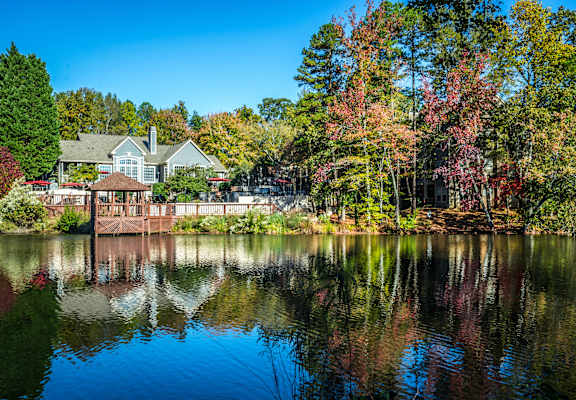 a view of a lake with a house in the background at Radbourne Lake Apartments, Charlotte