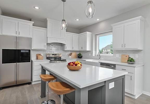 A modern kitchen with a large island and stainless steel appliances.