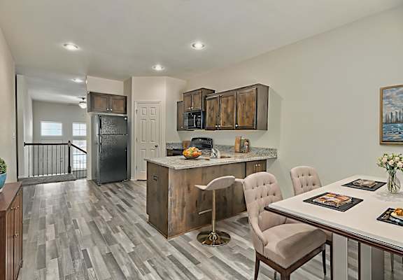 A kitchen with a dining table and chairs.