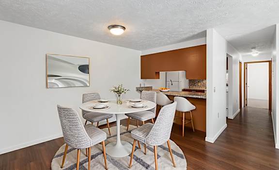 A dining room with a white table and grey chairs.