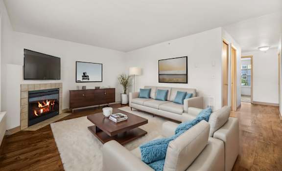 a living room with couches and a coffee table and a fireplace