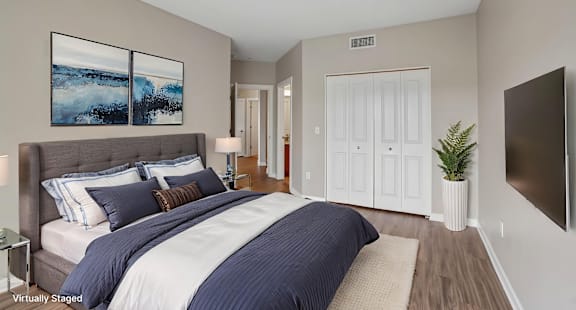 A bedroom with a large bed and a painting on the wall.