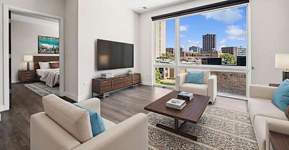 A living room with a large window overlooking a cityscape.