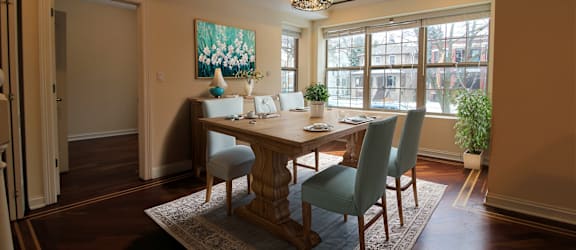 a dining room with a table and chairs and a large window