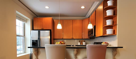 a kitchen with a bar with two stools