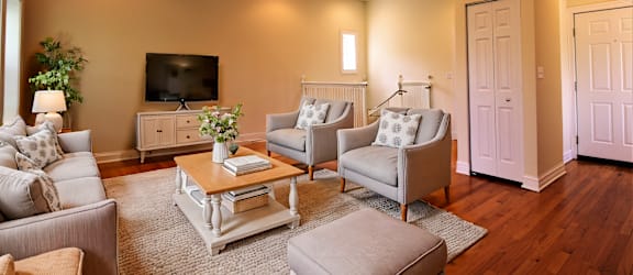 a living room with couches and chairs and a tv